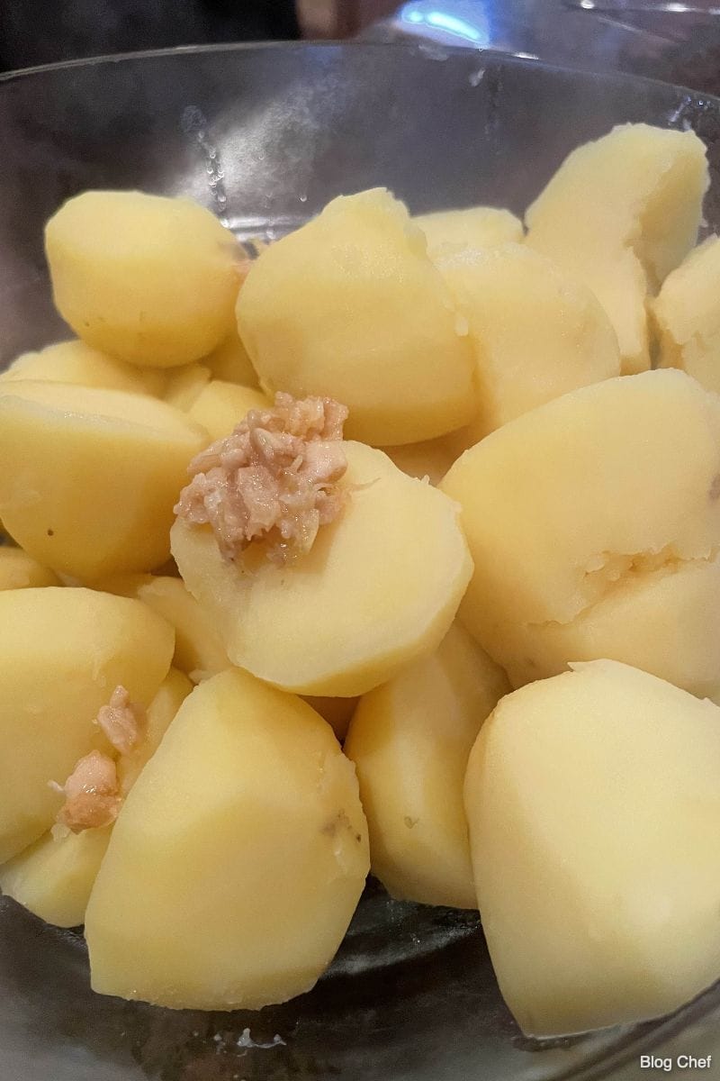 Boiled potatoes with roasted garlic, ready for mashing. 