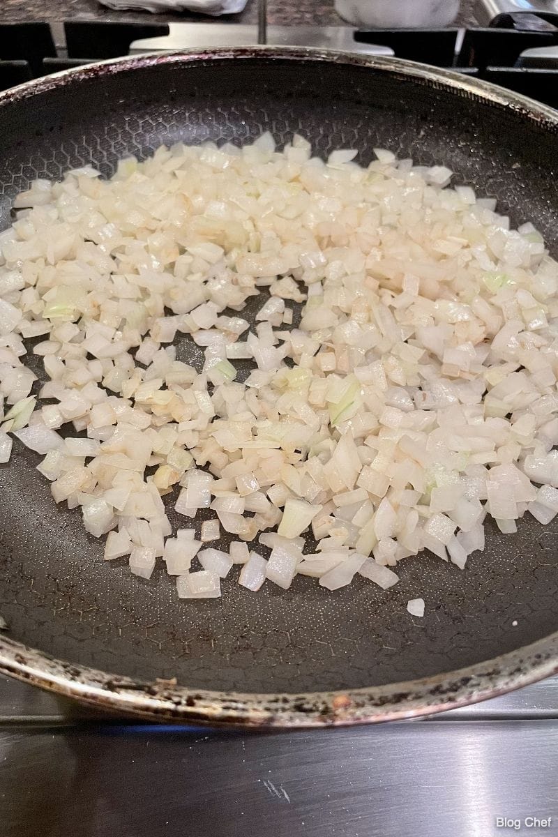 Chopped onions cooking in skillet for easy Asian lettuce wraps.