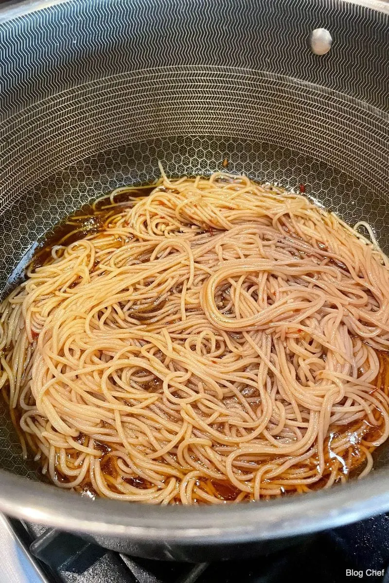 Noodles in sesame and garlic sauce in pot.