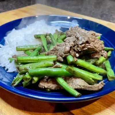 Close up view of black pepper beef prepared with green beans.