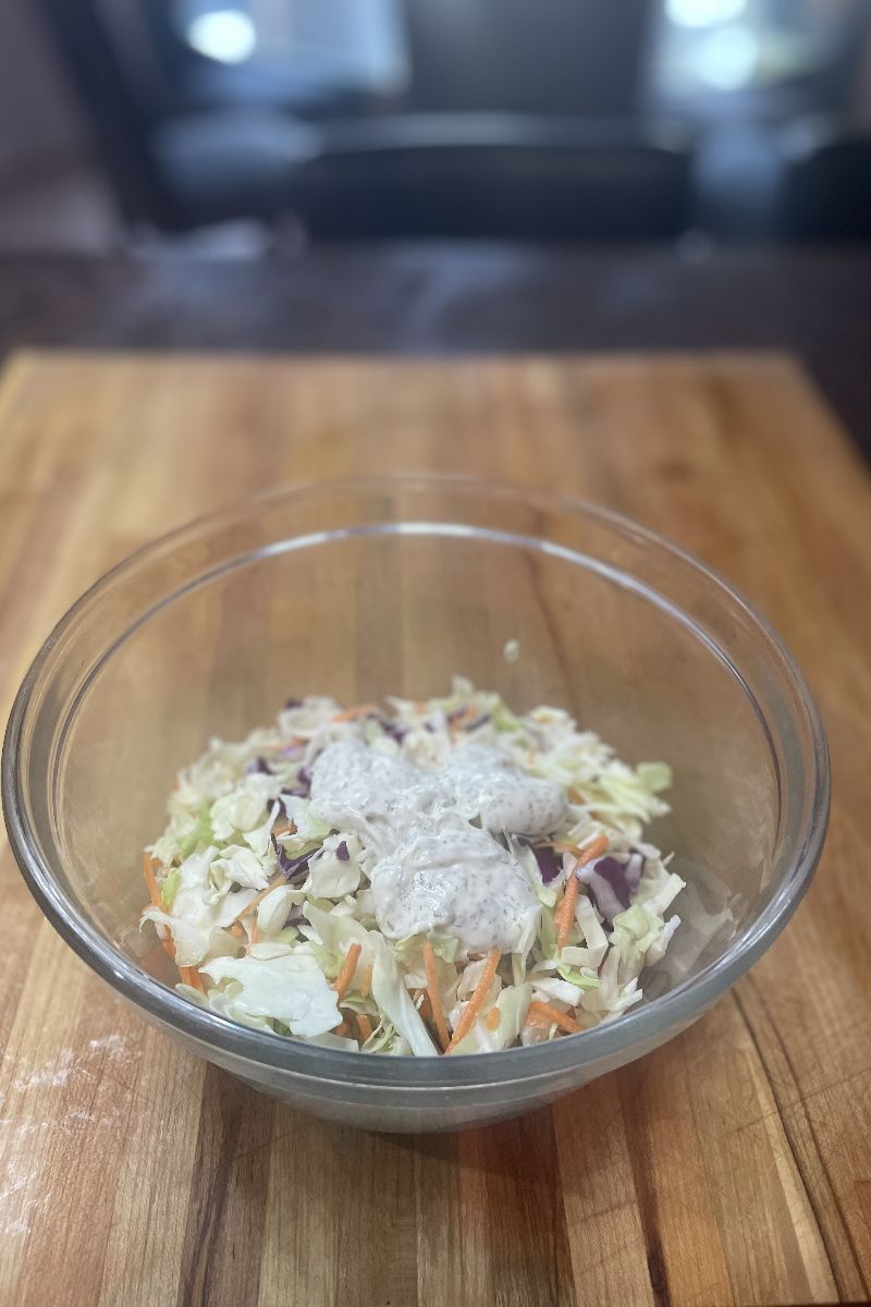 Top view of bowl of slaw mix with salad dressing.
