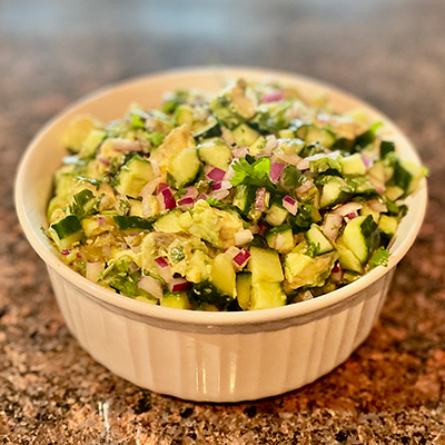 Close up view of cucumber avocado salsa in a bowl.