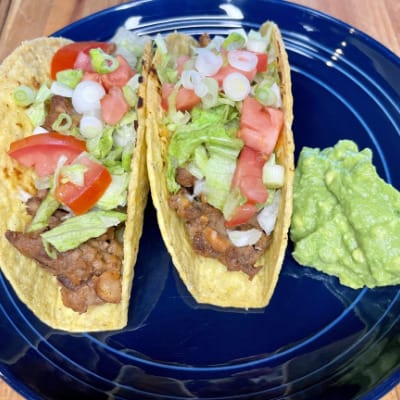 Prepared baked tacos on plate with guacamole.