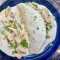Chicken tacos prepared on plate with soft flour tortillas.