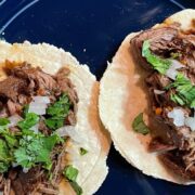 Prepared slow cooker barbacoa tacos on plate.