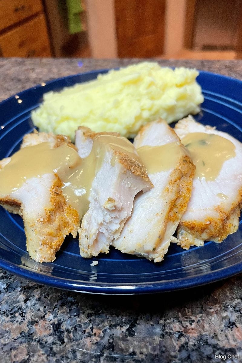 Slow cooker turkey breast, prepared and sliced with gravy and mashed potatoes.