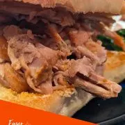 Close up view of pulled pork on ciabatta roll with text overlay.