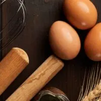 Eggs and wheat on dark surface.