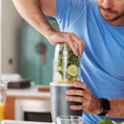 Healthy man makes smoothie as part of a bodybuilder food diet.