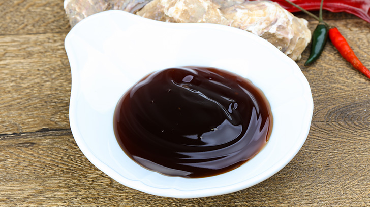 Close up view of oyster sauce in white bowl.