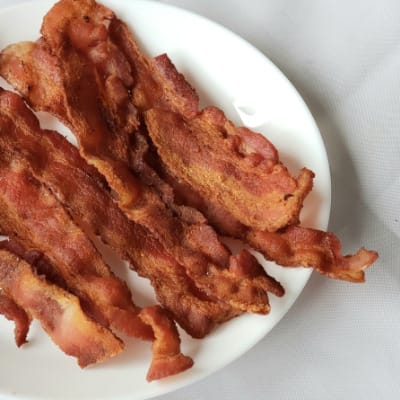 Plate of crispy, cooked bacon.