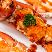 Cooked lobster tail on serving dish.