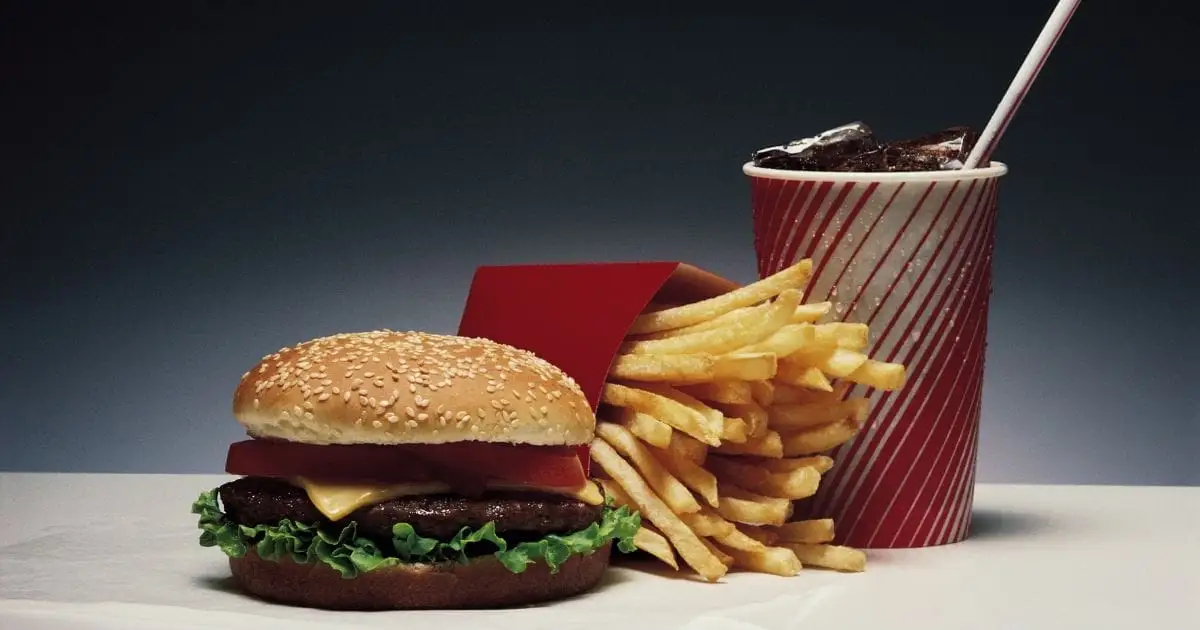 Burger, fries, and soda on surface.