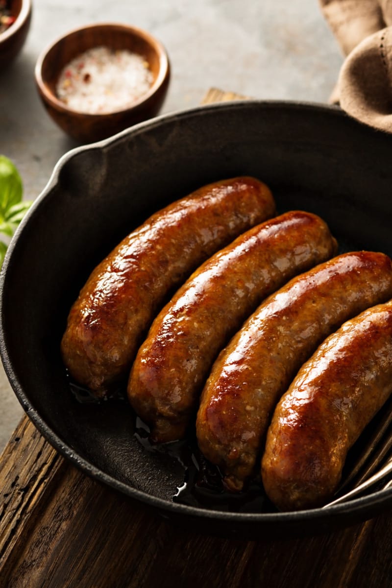 Italian sausage cooked on stove in skillet.