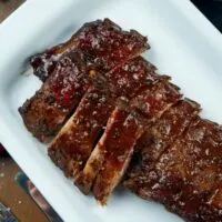 Prepared smoked ribs in serving dish.