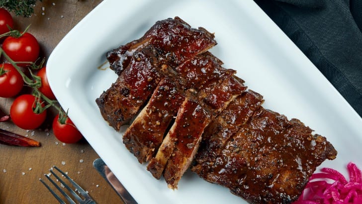 Prepared smoked ribs in serving dish.