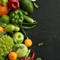 An assortment of raw vegetables on a dark background.