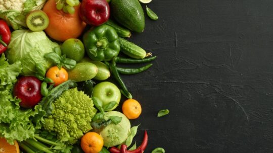An assortment of raw vegetables on a dark background.