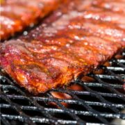 Baby back ribs cooking on gas grill.