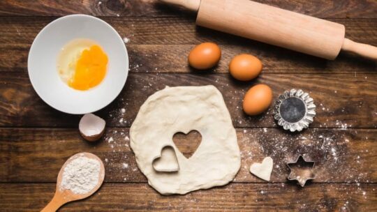 Eggs, dough, and rolling pin on cutting board to represent what can I substitute for eggs in baking.
