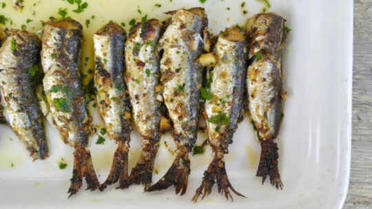 Top view of whole sardines prepared on plate.