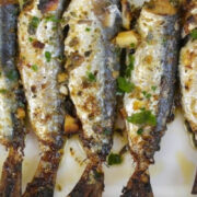 Top view of whole sardines prepared on plate.