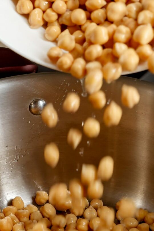 Pouring soaked beans into pot.