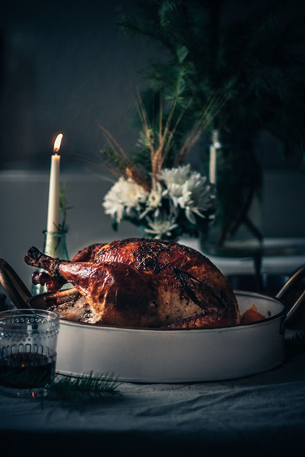 Beautifully roasted whole turkey in a serving dish to represent how long to cook a turkey.