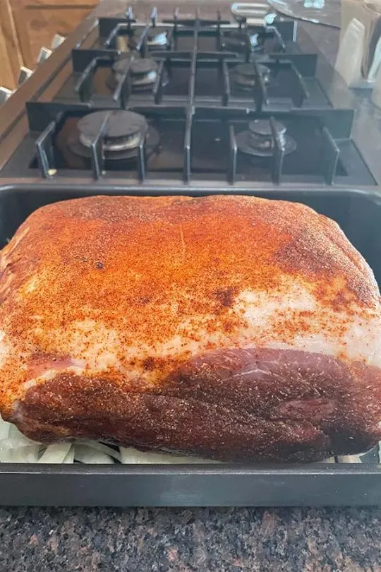 Seasoned pork shoulder in roasting dish, ready to go in the oven. 