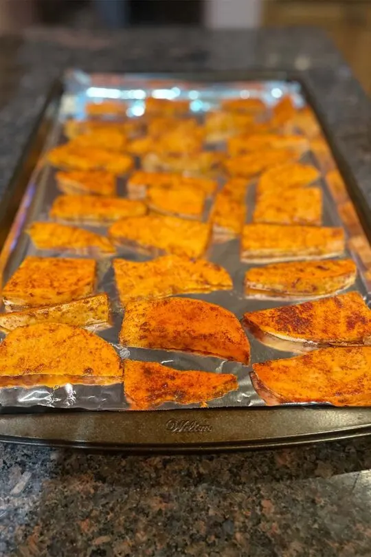 Baked yam wedges on cookie sheet.