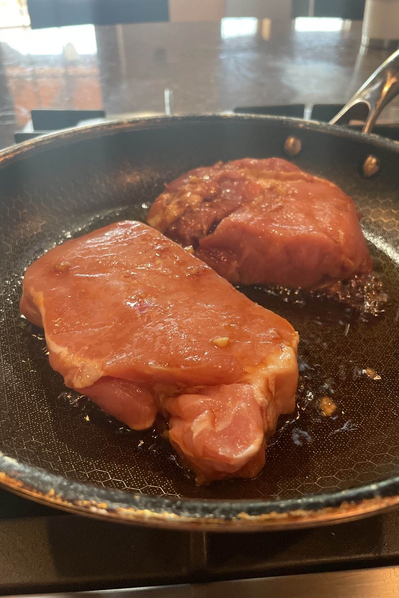 Korean style pork chops cooking in skillet. 