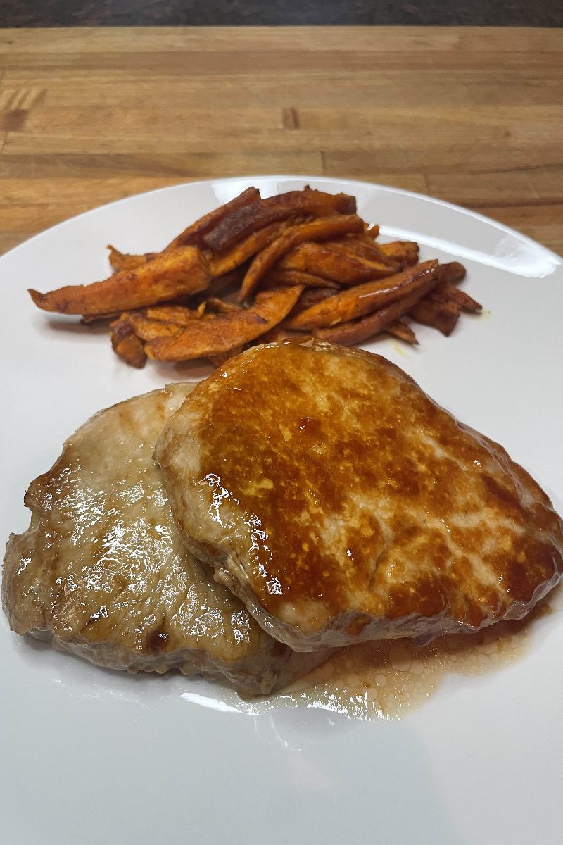 Baked pork chops served with sweet potato fries. 
