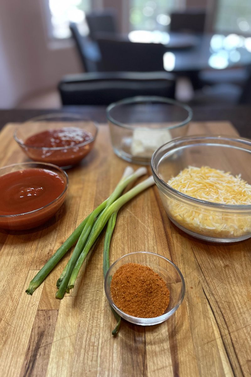 Ingredients for taco stuffed shells on a cutting board.