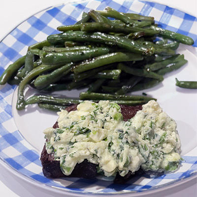 Oven-roasted green beans with steak on plate.