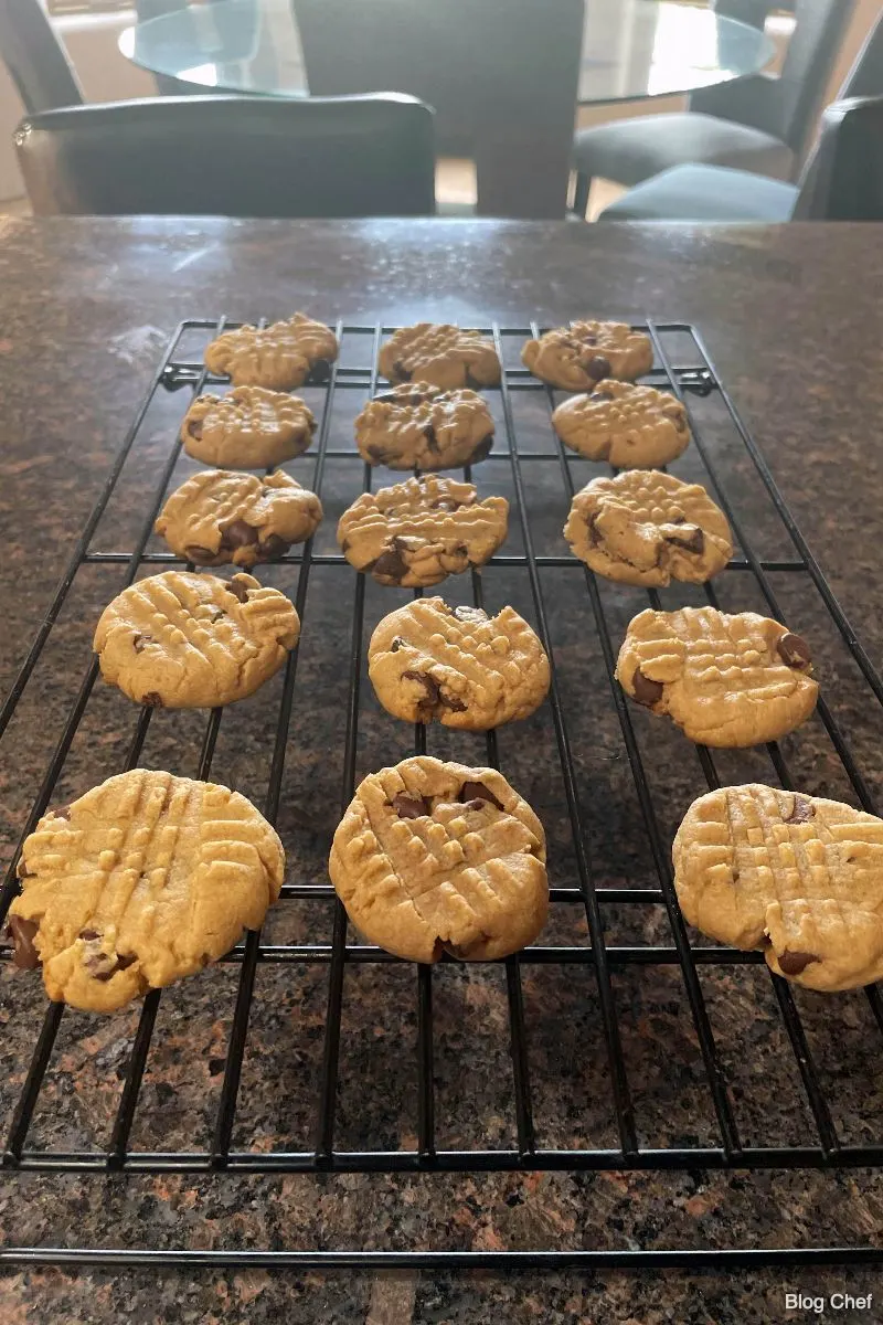 Freshly cooked chocolate chip peanut butter cookies on wire rack.